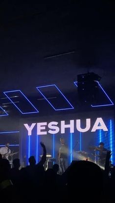 the band yeshuaa performing on stage with their hands in the air as they sing