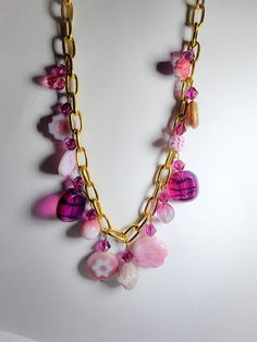 Designer Czech glass charms and fuschia Swarovski bicones dangle from a 10k gold plated 16in chain necklace. Multiple hues of pink. Luxury Czech Glass Necklaces, Pink Necklace With Adjustable Chain, Pink Chain Necklaces For Gifts, Pink Dangle Charm Necklace With Adjustable Chain, Handmade Pink Czech Glass Jewelry, Handmade Pink Chain Necklace As Gift, Pink Beaded Chain Jewelry For Gift, Pink Beaded Chain Necklace As Gift, Handmade Pink Czech Glass Necklaces