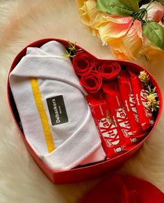 a red heart shaped box filled with candy and other items