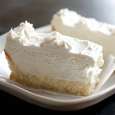 two pieces of cake on a plate with white frosting and icing sitting next to each other