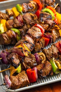 several skewers of meat and vegetables on a tray