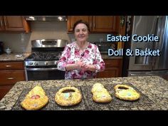 a woman standing in front of three cookies on top of a kitchen counter with the words easter cookie doll and basket