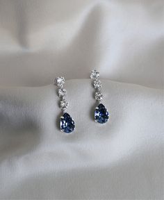 Introducing our new favorites: MB Sapphire Drop Earrings. Made with sparkling Swarovski crystals and plated with Rodhium for an extra touch of shine, these earrings will elevate any outfit. With the rich blue sapphires, the MB Sapphire Drop earrings are a true statement of elegance and luxury. Made of 925 Sterling Silver and plated with Rhodium for extra shine. Formal Blue Crystal Earrings, Blue Diamond-accented Evening Earrings, Blue Cubic Zirconia Drop Earrings, Sapphire Crystal Drop Earrings For Formal Occasions, Elegant Blue Crystal Earrings, Elegant Blue Drop Crystal Earrings, Elegant Sapphire Crystal Drop Earrings, Sapphire Drop Crystal Earrings, Blue Sterling Silver Crystal Earrings For Formal Events