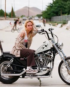 a woman sitting on top of a motorcycle