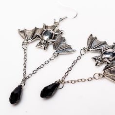 Unleash your inner darkness with these captivating Bat Earrings. Crafted from durable zinc alloy with a striking black finish, each earring measures 1.5 by 1 inch, featuring an elegant 1-inch chain adorned with a black diamond-shaped accent. Perfect for adding a touch of gothic charm to any outfit, these earrings are a must-have for your collection. Silver Alloy Jewelry For Evening, Adjustable Silver Gothic Jewelry, Adjustable Gothic Silver Jewelry, Gothic Silver Pewter Jewelry, Gothic Pewter Jewelry In Silver, Silver Gothic Jewelry For Jewelry Making, Nickel-free Adjustable Surgical Steel Jewelry, Adjustable Nickel-free Surgical Steel Jewelry, Edgy Halloween Jewelry