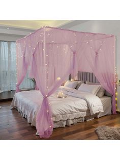 a pink canopy bed with lights on it