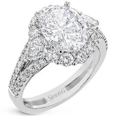 a diamond engagement ring with two pear shaped diamonds in the center and side stones on each band