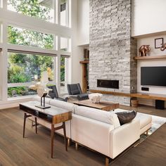 a living room with white furniture and large windows