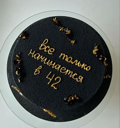 a black cake with gold writing on it