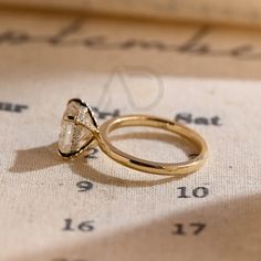 a diamond ring sitting on top of a piece of paper with numbers in the background