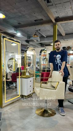 a man standing next to a chair in a room filled with mirrors and other furniture