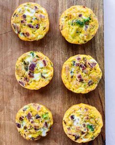 six muffins with cheese and vegetables on a wooden board