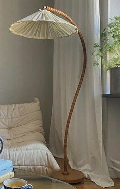 a lamp that is sitting on top of a table next to a couch and window