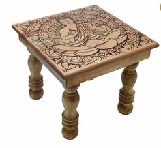 a small wooden table with an intricate design on the top and bottom, sitting in front of a white background