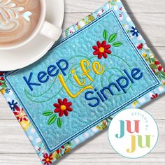 a cup of coffee sitting on top of a table next to a blue mat with the words keep life simple