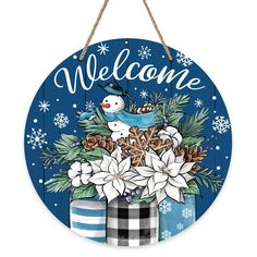 a welcome sign hanging on a wall with snowflakes and poinsettis