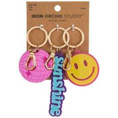 three key chains with smiley faces and the word iron orchid studio on it's front