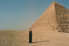 a person standing in front of a large pyramid