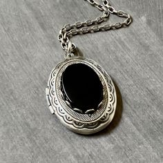 Antique Silver Onyx Locket Necklace....  This locket necklace is beautiful!  The locket is made of brass and is antique silver plated.  To the center of the locket, I added a flat top oval black onyx cabochon that sits in an antiqued silver brass setting. The high quality chain has soldered links and is non tarnish.  The chain closes with a lobster claw clasp.         Locket - 29mm height x 22mm width approximately Interior photo area - 20mm x 15mm wide approximately Chain - 24 inches long This sweet vintage style locket would be perfect to add photos of relatives, friends or pets. Your locket necklace will come to you gift wrapped!   More beautiful lockets!  https://www.etsy.com/shop/dayslonggone/?etsrc=sdt&section_id=6107145 Nature and vintage inspired necklaces!  https://www.etsy.com/sh Photo Area, Locket Necklace Vintage, Interior Photo, Necklace Vintage, Locket Necklace, Mother's Day Gift, Black Onyx, Lobster Claw, Locket