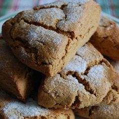 a pile of cookies sitting on top of a white plate covered in powdered sugar