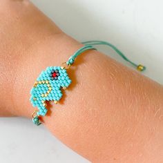 a woman's arm with a bracelet made out of seed beads and glass beads