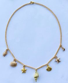 Introducing the cutest Dainty Gold Conch Shell Charm Necklace, adorned with an array of exquisite beach-inspired charms. This stunning piece uses a simple gold chain to captures the essence of the ocean, bringing a touch of elegance and sophistication to any ensemble.  The centerpiece of this necklace is a radiant gold conch shell, symbolizing tranquility, beauty, and the serenity of the coast. Adorning either side of the conch are intricately designed gold starfish, gold clam shells, and gold s Cheap Starfish Charm Jewelry For Vacation, Gold Shell Necklace With Starfish Charm For Summer, Beachy Gold Shell Necklace As A Gift, Beachy Gold Shell Necklace For Gift, Beachy Gold Shell Necklace Perfect For Gifts, Beachy Gold Shell Necklace For Gifts, Gold Shell Necklace With Starfish Charm For Vacation, Necklaces With Charms, Beachy Gold Jewelry With Starfish Charm