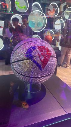 a basketball sitting on top of a purple table in front of a wall with mirrors