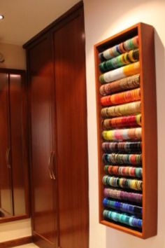 a closet with many different colored towels hanging on the wall and a mirror behind it