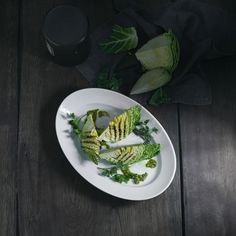 a white plate topped with cut up broccoli on top of a wooden table