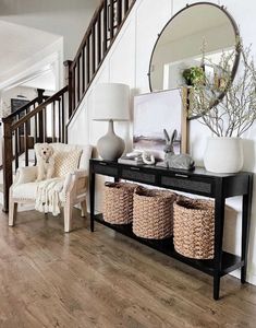 a living room filled with furniture next to a stair case covered in wicker baskets