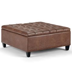 a brown leather ottoman sitting on top of a white floor