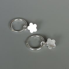 A PAIR of sterling silver hoops. Comes with a detachable cut out flower charm. The charm is multipurpose and can be used with a neck or bracelet chain too. Dimension: Hoop- 12 x 1.5 mm Charm: 7 x 11 mm Drop length- 21 mm These earrings are made of 925 hypoallergenic sterling silver and plastic. Please note this price is for ONE PAIR. All my pieces are sent in a gift box. I can include a personal message from you if needed You are welcome to contact me at... bhavnakwintra1956@gmail.com For more b Nickel Free White Sterling Silver Huggie Earrings, Round Hoop Earrings With Flower Charm As Gift, Sterling Silver Earrings With Flower Charm For Everyday, Silver Charm Earrings For Everyday, Silver Earrings With Flower Charm For Everyday, Silver Earrings With Dangling Charms, Everyday Silver Earrings With Flower Charm, Handmade Silver Huggie Earrings For Gift, Small Hoop Earrings With Flower Charm As Gift