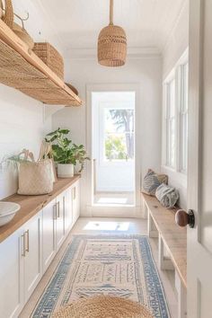 a hallway with white walls and wooden shelves filled with baskets hanging from the ceiling next to a blue rug