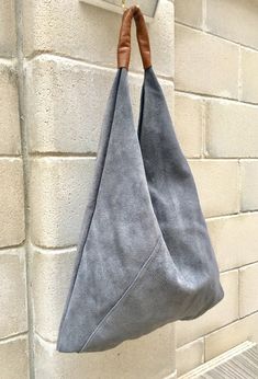 LARGE tote leather bag in GRAY. Slouch bag in genuine SUEDE leather. NOT LINED.  We added  a small leather zipper pouch for your mobile phone and/or cards or money.  It ist attached to the inside of the bag with a piece of suede in the same green color. Genuine leather accent shoulder piece in camel brown.  This listing is for the bag in GRAY , also available in green and  beige.  The bag is closed with suede bands, no zipper.  Width at the base : 43 cm - 17 in Height at the center, without the Slouch Handbag Purses, Luxury Suede Bags For On-the-go, Luxury Canvas Hobo Bag With Removable Pouch, Modern Suede Hobo Bag With Double Handle, Modern Double Handle Suede Hobo Bag, Modern Suede Tote Hobo Bag, Modern Suede Hobo Bag With Leather Handles, Suede Hobo Satchel Bag For Shopping, Modern Suede Shoulder Bag With Textured Leather