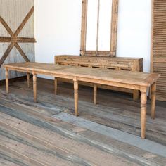 an old wooden bench and mirror in a room with wood flooring on the walls