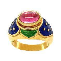 Lovely 18 karat yellow gold ring designed with the intention of a flower. The ring centers an oval cabochon pink tourmaline set horizontally. Green and blue enamel accent the center stone. Ring size 7.5 Stamped Cellini 750 Luxury Ceremonial Hallmarked Enamel Ring, Luxury Yellow Gold Enamel Ring With Cabochon, Gold Ring Designs, Green Enamel, Yellow Gold Ring, Oval Cabochon, Pink Tourmaline, Yellow Gold Rings, Solitaire Ring