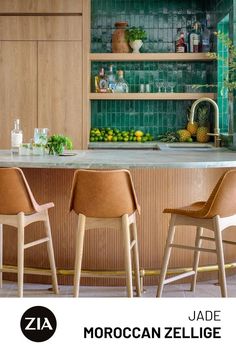 A wooden bar is met with tan leather stools as a green zellige backsplash showcases glassware and citrus fruits. Roof Tiles Design, Tommy Bahama Kitchen, Zia Tile, Moroccan Architecture, Tiles Design, Roof Tiles, Kitchen Tile, Architecture And Design, Outdoor Kitchen Design