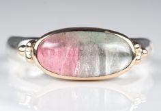 "Sterling silver and solid 14K yellow gold ring. Featuring a long oval shaped cabochon watermelon tourmaline. Attractive light pastel colours. Well balanced and elegant. Classic timeless simple design. Very durable and secure solid 14K gold bezel set center stone. Solid 14K gold triple bead shoulder decor Low profile  easy to wear.  Solid sterling silver band. Handmade ,  one of a kind ATTENTION TO ALL CANADIAN RESIDENTS:  Federal GST sales taxes as well as Provincial sales taxes are included in Colour Pastel, Purchase Invoice, Watermelon Tourmaline Ring, Cut Watermelon, Etsy Gold Ring, Pastel Colours, Tourmaline Ring, Watermelon Tourmaline, 14k Gold Ring