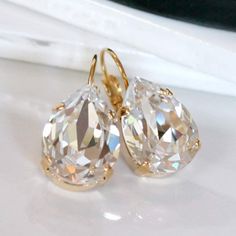 "These gorgeous earrings display dazzling Swarovski clear crystal teardrops are set in gold-plated bezels on gold lever back earrings.  Perfect for that special occasion!  These earrings also come in a smaller size. Below is the link: https://www.etsy.com/listing/546010172/swarovski-clear-crystal-teardrops-set-in?click_key=eef914f56d4f151bb0a1ab28c706eff67d7864a8%3A546010172&click_sum=71848a15&ref=shop_home_feat_3&frs=1 * Swarovski Crystal Clear Teardrops- 1/2x3/4\"(13x18mm) * Gold-Plated Bezels and Earrings * Length- 1 1/4\"(31mm) * Nickel Free These earrings come in a jewelry bag and gift box." Teardrop Earrings Gold, Swarovski Crystal Drop Earrings, Clear Crystal Earrings, Crystal Teardrop Earrings, Cheap Earrings, Crystal Bridal Earrings, Teardrop Dangle Earrings, Wedding Jewelry Earrings, Cheap Jewelry