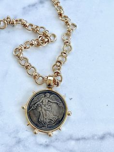 This beautiful French commemorative coin hangs from a substantial gold chain which can also be worn on its own, so you have two necklaces in one.   The pendant measures just less than two inches across and the chain can be purchased in shorter to longer lengths.  This chain is heavily plated in 14kt gold and is free of nickel or lead.  The finish will remain beautiful over time.   We do recommend that you do not allow perfume, hair spray or other chemicals to get on any of your jewelry. Gold-tone Medallion Necklace With Coin Pendant, Bronze Coin Pendant Necklace, Bronze Medallion Necklace With Coin Pendant, Antique Gold Coin Necklace In Brass, Gold Chain Medallion Necklace, Gold Chain Medallion Necklace As Gift, Antique Gold Coin Pendant Medallion Necklace, Gold Medallion Coin Necklace In Brass, Gold Brass Medallion Coin Necklace