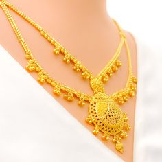 This 22k gold long necklace set features an ornamental tasseled drop design, perfect for adding elegance to any outfit. Weighing 53.9 grams, it showcases a yellow gold finish that enhances its intricate and eye-catching appearance. The set has a length of 24 inches with a 2.25-inch drop and includes adjustable 1.5-inch links for a comfortable fit. Secured with a hook lock, it combines style and practicality. The matching earrings, each 1.75 inches long, feature screw back posts for added security. Ideal for those who appreciate luxurious and sophisticated jewelry, this set brings a touch of opulence and tasseled charm to your collection. PRODUCT DETAILS Gold Purity(karat): 22k Gold Weight(grams): 53.9 Item Finish: Yellow Gold Set Length: 24" Drop Length: 2.25" Adjustable Links: 1.5" Links Traditional Yellow Gold Long Temple Necklace, Traditional Long Yellow Gold Temple Necklace, Yellow Gold Plated Chandbali Necklace, Gold Long Temple Necklace With Intricate Design, Gold Temple Necklace With Intricate Design, Yellow Gold Necklaces With Latkans For Festivals, Ceremonial Yellow Gold Necklaces With Latkans, Elegant Gold Temple Necklace With Latkans, Elegant Gold Plated Bridal Necklace With Latkans