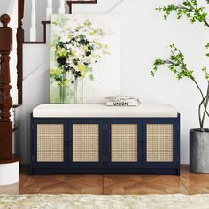 a blue bench sitting under a painting next to a stair case and potted plant