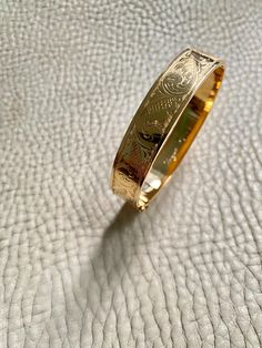 Made in 1962 - Wide Hinged Bangle in 18k gold - Etched Curls Pattern - Stockholm, Sweden - Size 7 Stunning vintage hinged bangle crafted in 18k yellow gold. Bangle was made in 1962 by maker GFP active 1945-1968. Bracelet has full Swedish hallmarks for maker, year, location and gold purity. By hand, the goldsmith etched a wonderful swirling curl pattern on one side of the bangle and polished the other side - you can wear her either way - a two in one! She is oval shaped measuring 7 inches inside Vintage Yellow Gold Bangle Stamped 14k, Vintage 14k Stamped Yellow Gold Bangle, Luxury Gold Plated Cuff Bracelet With Polished Finish, Antique Hallmarked Yellow Gold Bangle, Antique Yellow Gold Hallmarked Bangle, Vintage 14k Gold Hallmarked Bangle, Vintage 14k Stamped Gold Bangle, Vintage Yellow Gold Bangle For Gift, Vintage Yellow Gold Bangle Gift