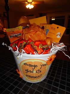 a bucket filled with candy and candies sitting on top of a tiled countertop