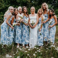 a group of women standing next to each other on top of a grass covered field