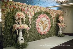 the floral wall is decorated with flowers and monogrammed letters on it's sides