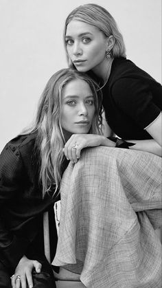 two women sitting next to each other on a bench