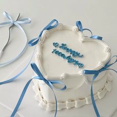 a heart shaped cake with the words happy birthday written in blue icing on it