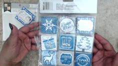 someone is holding up some blue and white stickers in their hands with snowflakes on them