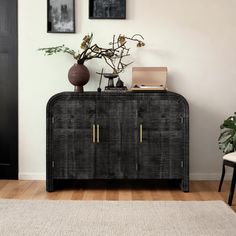 a black cabinet sitting on top of a hard wood floor next to a white rug